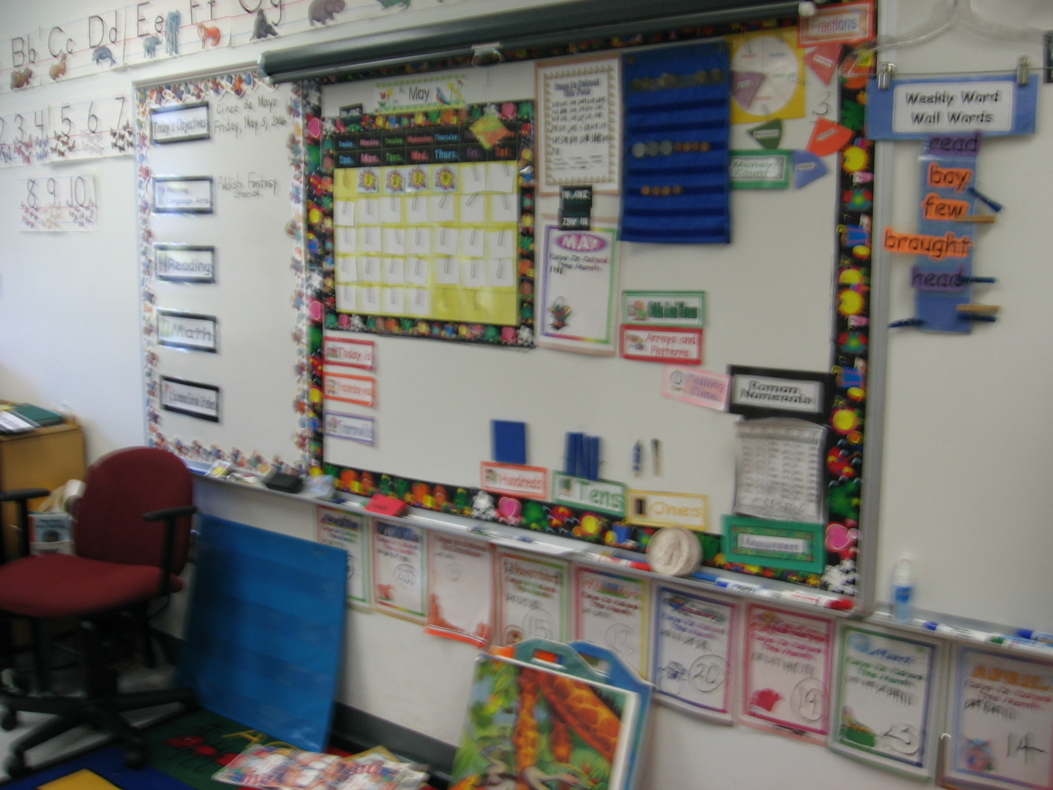 Mrs. Joyce, 1st Grade. Sorry for the blur! See if you can make out the week’s word wall words on the right–they’re hanging there by clothespins. I also like the magnetized place value pieces, and the way she used borders to create various sections of the whiteboard. Below the board it looks like they did some kind of counting activity for each month.